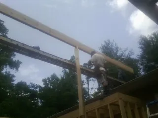 Carpenter setting a ridge beam over a new addition frame — Ice Dam Removal by Roofing Brothers in Dana Point