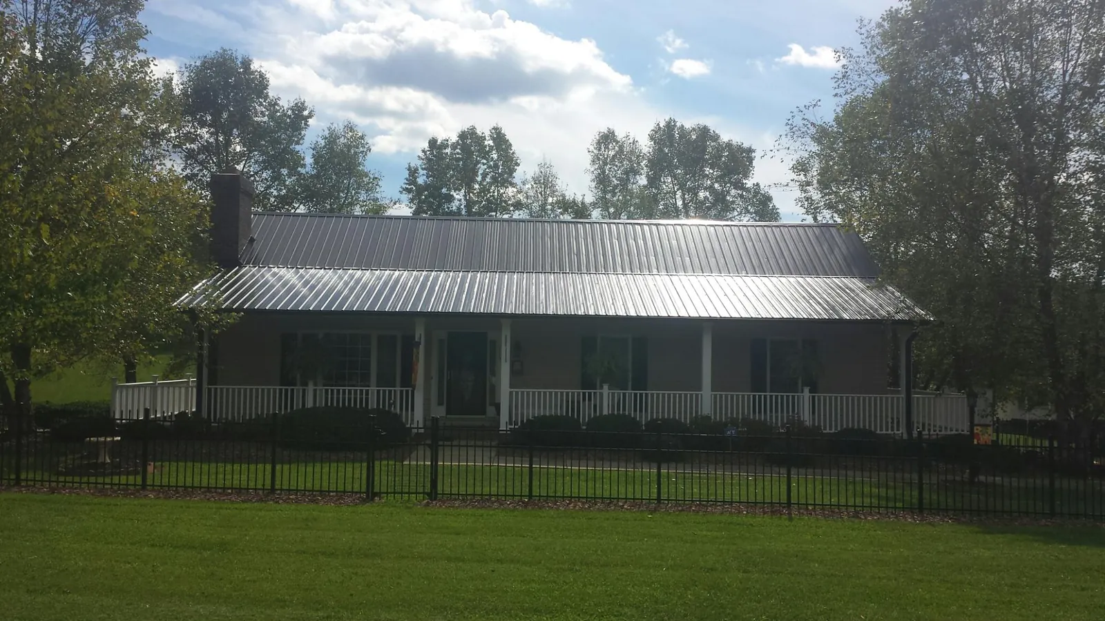 Gray metal roof on a brick ranch with a full width front porch — Gutter Guard Installation work by our crew in Dana Point